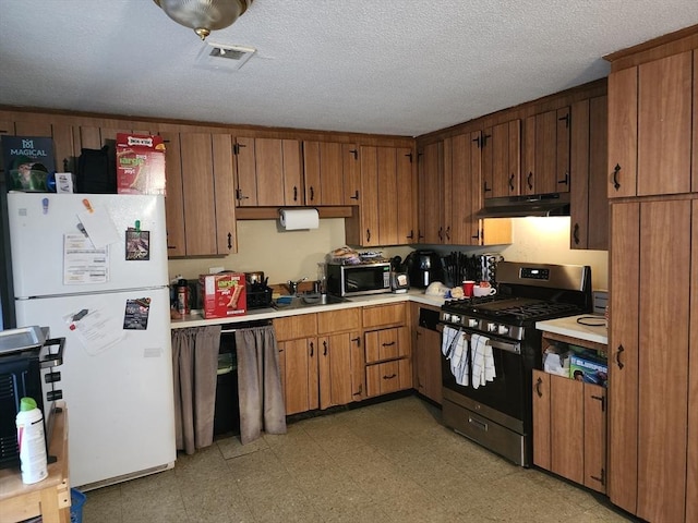 kitchen with a sink, visible vents, under cabinet range hood, light countertops, and appliances with stainless steel finishes