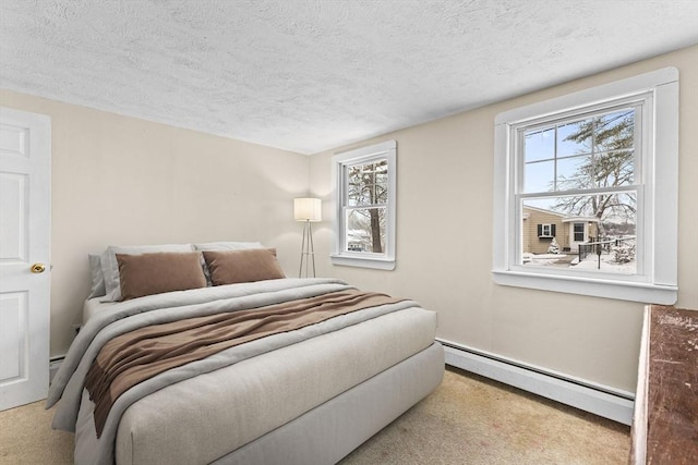 bedroom with a baseboard radiator, a textured ceiling, and light carpet