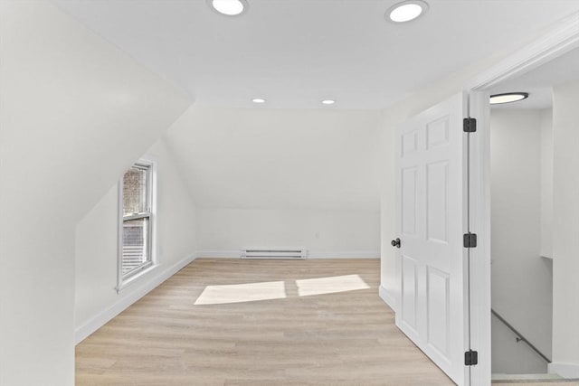 bonus room with lofted ceiling, light wood-type flooring, and a baseboard heating unit