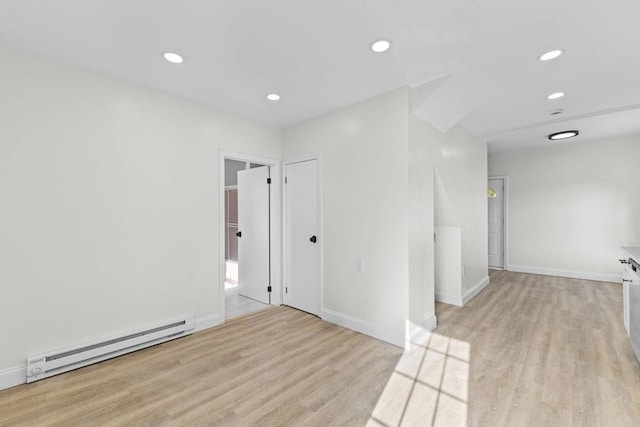 spare room featuring light wood-type flooring and a baseboard radiator