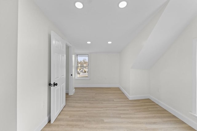 hall featuring light hardwood / wood-style flooring and vaulted ceiling