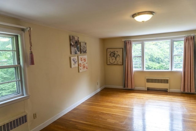 118 Dudley Ln, Milton, MA 02186 - spare room featuring radiator heating unit, healthy amount of natural light, and wood finished floors