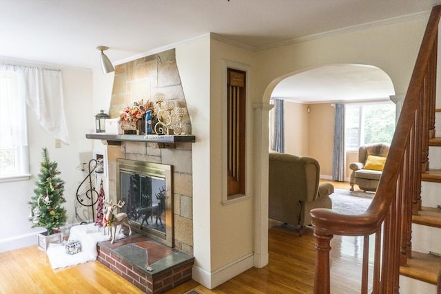 118 Dudley Ln, Milton, MA 02186 - living area with arched walkways, wood finished floors, baseboards, ornamental molding, and a large fireplace