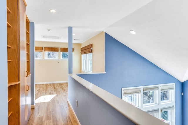 hall featuring vaulted ceiling and light hardwood / wood-style flooring