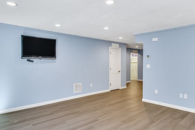 unfurnished room featuring light hardwood / wood-style floors and crown molding