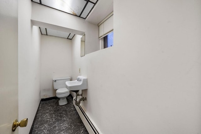 bathroom featuring a baseboard heating unit, sink, and toilet