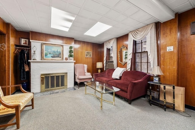 carpeted living room with cooling unit, a fireplace, and wood walls