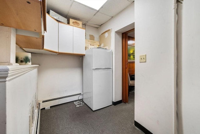 kitchen with white cabinetry, carpet, a drop ceiling, a baseboard radiator, and white fridge