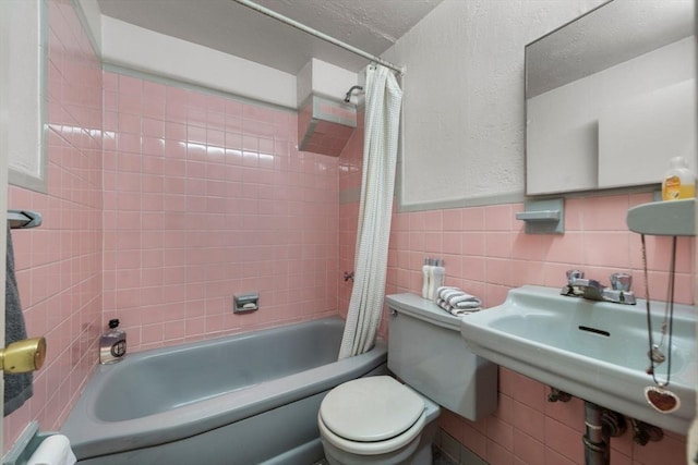 full bathroom featuring shower / bath combination with curtain, toilet, sink, and tile walls