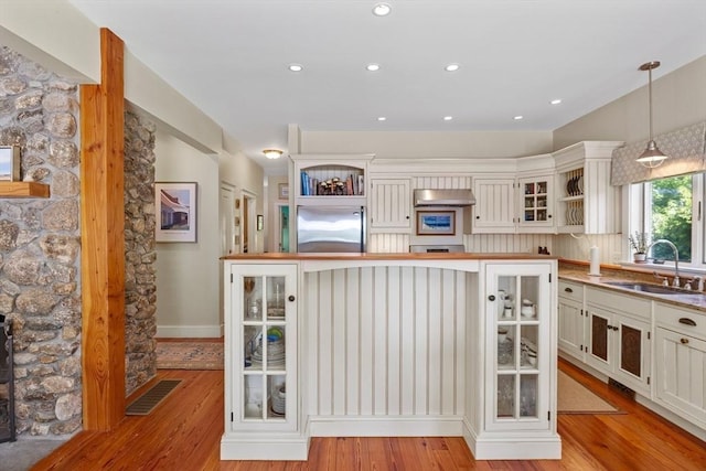 25 Richard Ln, Eastham, MA 02642 - kitchen with built in fridge, open shelves, light wood finished floors, glass insert cabinets, and pendant lighting