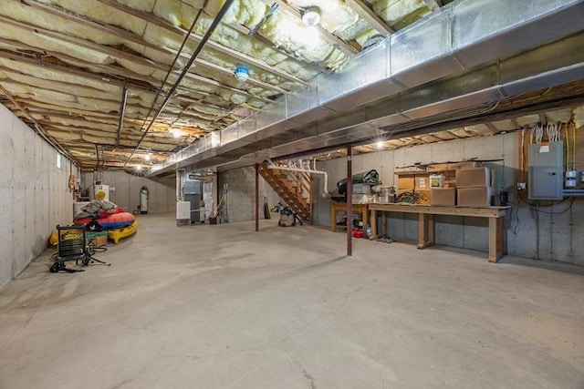 25 Richard Ln, Eastham, MA 02642 - unfinished basement with electric panel, water heater, stairs, heating unit, and a workshop area