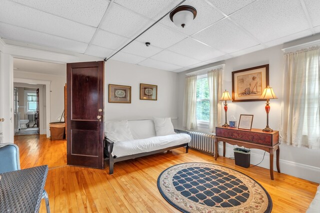 bedroom with light hardwood / wood-style floors and a paneled ceiling