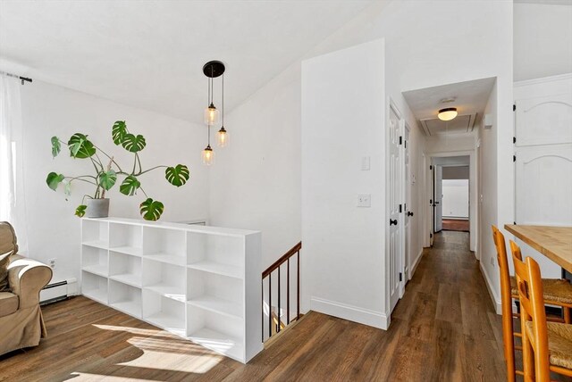 corridor with an upstairs landing, baseboards, dark wood finished floors, and baseboard heating