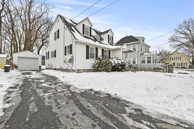 cape cod-style house with a garage and an outbuilding