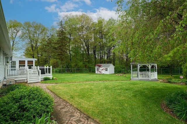 view of yard with a deck, a storage shed, and an outdoor structure