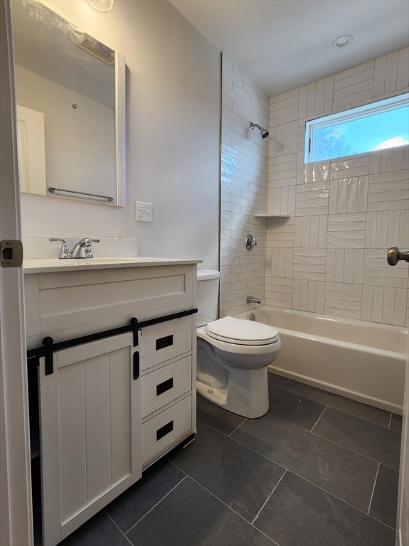 full bathroom featuring tile patterned floors, toilet, vanity, and tiled shower / bath