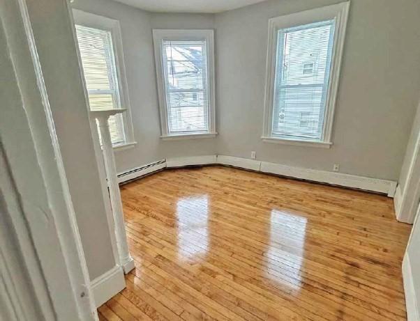 interior space with wood-type flooring and a baseboard radiator