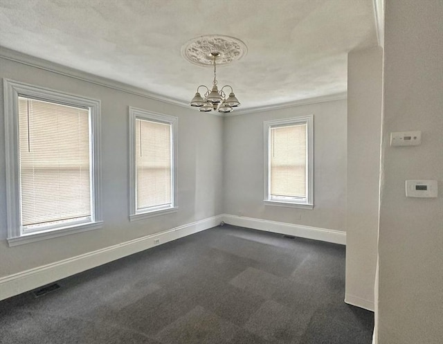 empty room featuring dark colored carpet, a notable chandelier, baseboards, and visible vents