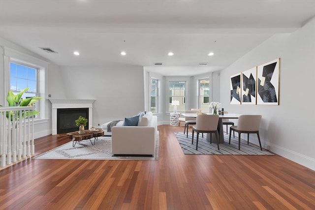 living room with beamed ceiling and wood-type flooring