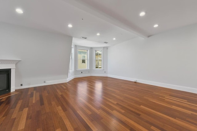 unfurnished living room with beamed ceiling and dark wood-type flooring