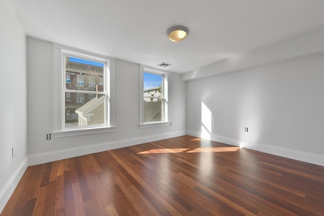 unfurnished room with dark wood-type flooring