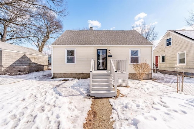 snow covered property featuring a shingled roof