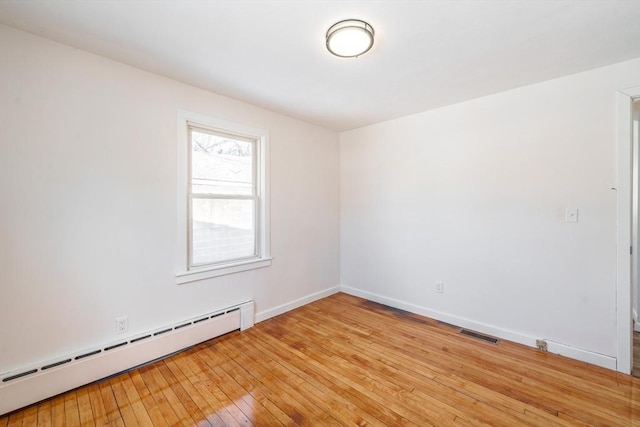 unfurnished room with light wood-type flooring, a baseboard radiator, visible vents, and baseboards