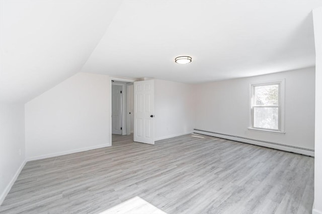 bonus room with vaulted ceiling, a baseboard radiator, light wood-style flooring, and baseboards