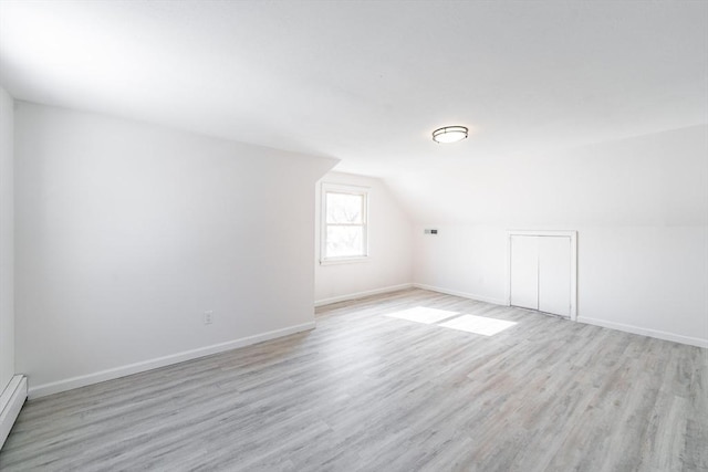 bonus room featuring lofted ceiling, baseboards, and light wood finished floors