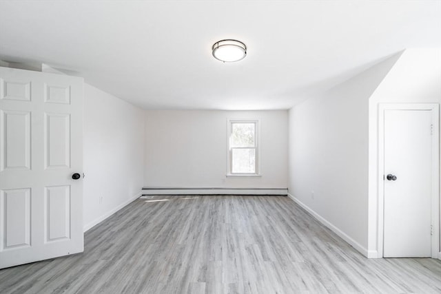 additional living space featuring light wood-style floors, a baseboard radiator, and baseboards