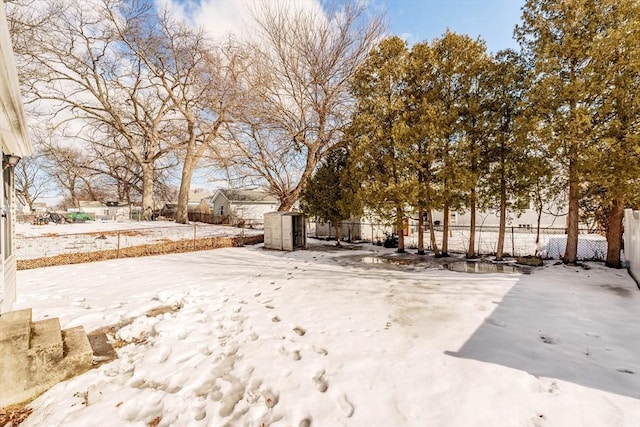 yard covered in snow featuring fence