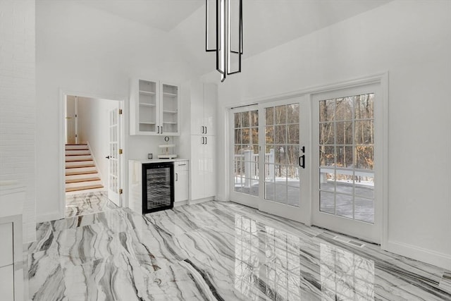 interior space with bar, beverage cooler, and french doors