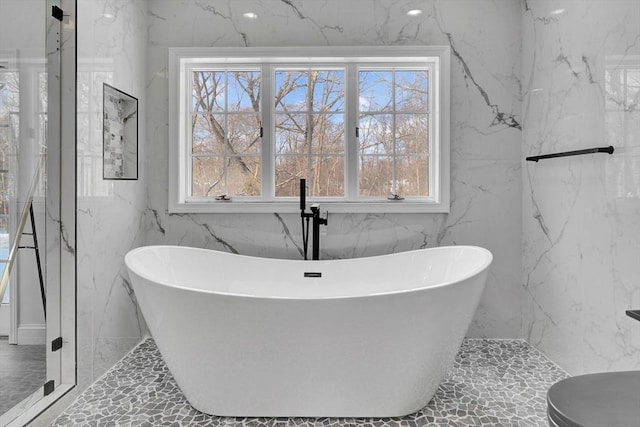 bathroom featuring a bathtub and a wealth of natural light