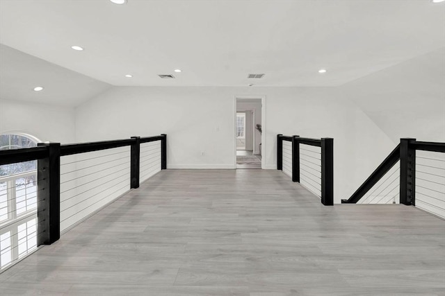 hall featuring lofted ceiling and light hardwood / wood-style floors