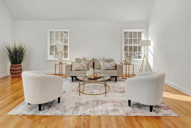 living room featuring hardwood / wood-style flooring, lofted ceiling, and a wealth of natural light