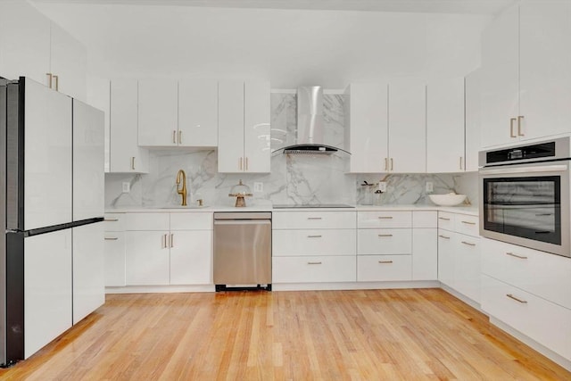 kitchen with white cabinetry, tasteful backsplash, stainless steel appliances, and wall chimney exhaust hood