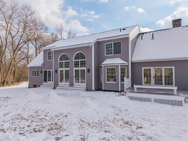 snow covered house with a deck