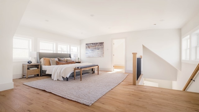 bedroom with light hardwood / wood-style floors and lofted ceiling