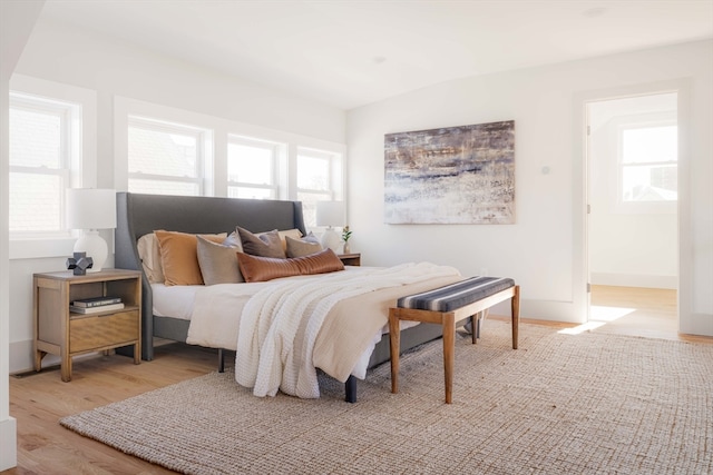 bedroom featuring light wood-type flooring and vaulted ceiling