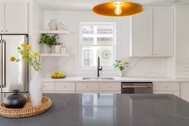 kitchen with white cabinets, backsplash, sink, and stainless steel appliances