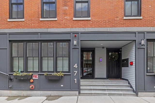 doorway to property featuring brick siding