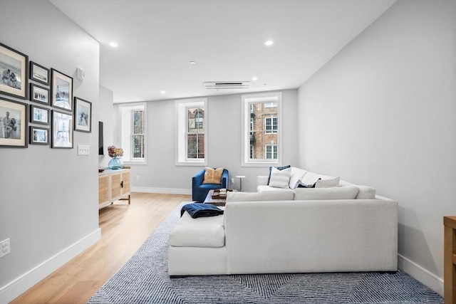 living room with recessed lighting, baseboards, and wood finished floors