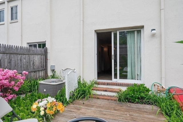 1 Charles St Unit W, Reading, MA 01867 - view of exterior entry featuring stucco siding, central AC, and a wooden deck