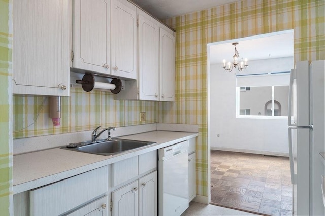 1 Charles St Unit W, Reading, MA 01867 - kitchen featuring white appliances, a sink, a chandelier, light countertops, and wallpapered walls