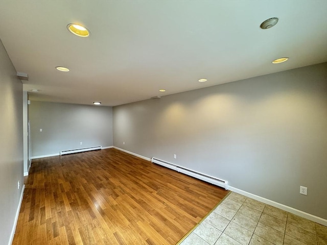 spare room featuring baseboards, a baseboard radiator, a baseboard heating unit, and wood finished floors