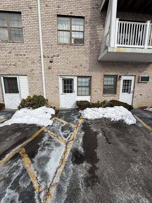 view of property exterior featuring uncovered parking and brick siding