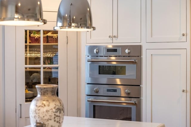 kitchen featuring stainless steel double oven and white cabinets