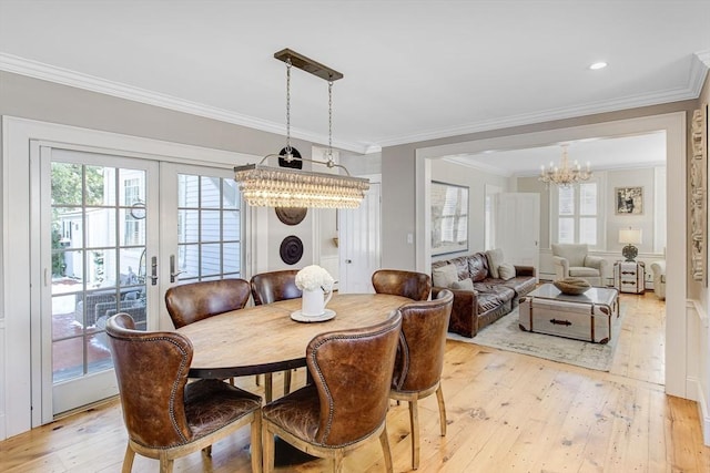 dining area with crown molding, plenty of natural light, and light hardwood / wood-style floors