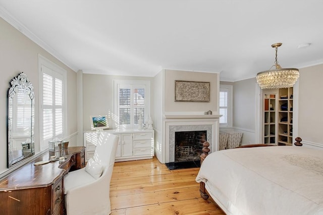 bedroom featuring multiple windows, crown molding, a chandelier, and light hardwood / wood-style floors