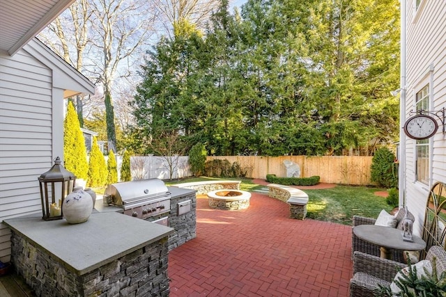 view of patio / terrace featuring grilling area, exterior kitchen, and a fire pit